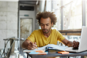 young man with open books and laptop