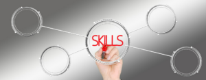 woman's hand writing the word "skills"