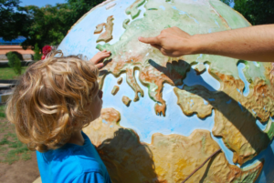 adult showing a child a country on a globe