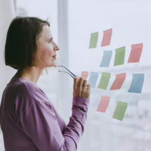 woman pondering sticky noted on wall