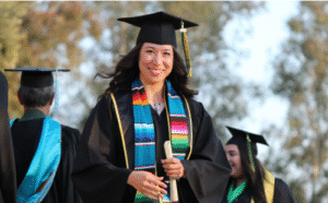 college graduate in regalia, holding a degree