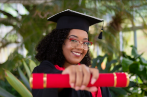 woman in regalia holding a diploma