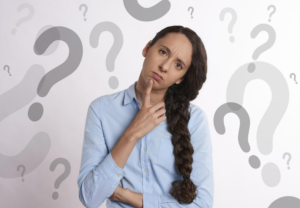 Woman pondering a decision, with question marks in the background