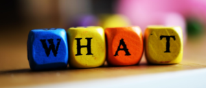 colorful small wooden cubes spelling the word "What"