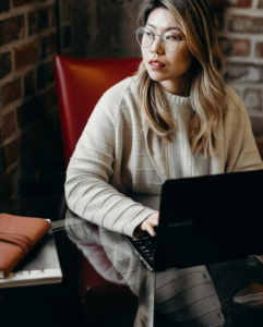 person writing with a laptop