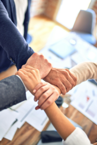 four people clasping each others' wrists