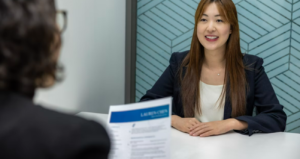 job interview; two people at a table, with one looking at a resume