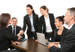 six business people in a group, all dressed in black suits